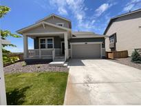 Charming single-Gathering home featuring a welcoming front porch and a two-car garage at 12892 E 99Th Pl, Commerce City, CO 80022