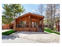 Charming cabin-style home featuring a covered porch and wooden accents in a serene, natural setting at 85 Revett Dr # 66, Breckenridge, CO 80424