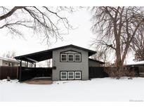 Gray house with black accents, covered carport, and snowy yard at 860 S Quivas St, Denver, CO 80223