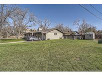 Charming single-story home featuring a well-maintained lawn and mature trees, perfect for outdoor enjoyment at 10150 W 25Th Ave, Lakewood, CO 80215