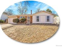 Charming home featuring brick and vinyl siding, a well-manicured lawn, and an attached garage at 2663 S Laredo St, Aurora, CO 80013