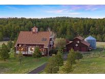 Stunning exterior view of home with mature trees and well-maintained landscaping at 11689 Caribou Dr, Franktown, CO 80116