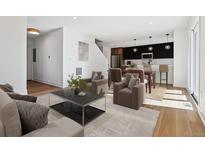 Open-concept living room with modern decor, hardwood floors, and abundant natural light from windows at 3432 W 25Th Ave, Denver, CO 80211