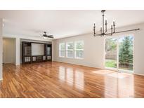 Spacious living room featuring hardwood floors, a ceiling fan, and a sliding door to the backyard at 5875 Raleigh Cir, Castle Rock, CO 80104
