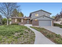 Charming two-story home boasts a well-manicured front yard and inviting walkway at 7380 Tabor St, Arvada, CO 80005
