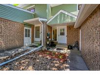 Charming townhome entrance with brick facade, green siding, and a small garden area at 1711 Cato Cir # 21, Lafayette, CO 80026