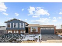 Ranch style home with gray siding, brick accents, and a two-car garage at 3124 W 9Th Avenue Pl, Broomfield, CO 80020