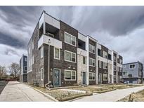 Modern townhome exterior featuring brick and white siding, balconies, and inviting blue front doors at 348 N Geneva St, Aurora, CO 80010