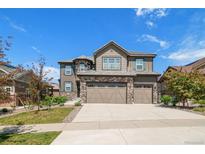 Charming two-story home featuring a three car garage, stone accents, and landscaped yard at 7720 S Queensburg Way, Aurora, CO 80016