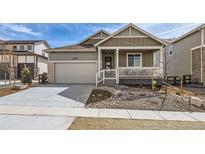 Charming home featuring a covered porch, two car garage, and manicured front yard at 4102 Estrella St, Brighton, CO 80601