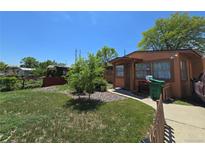 Charming single-story home featuring a well-maintained lawn and cozy front porch at 7371 Granada Rd, Denver, CO 80221