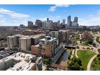 Stunning aerial view of the city skyline with modern apartment buildings and green spaces along the waterway at 1475 Delgany St # 307, Denver, CO 80202
