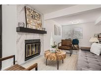Inviting living room with modern fireplace, stylish furniture, and an open concept layout, perfect for relaxing and entertaining at 180 S Nome St, Aurora, CO 80012