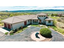 Elegant home boasts a circular driveway, tile roof, and stunning mountain views, perfect for luxurious living at 8611 Coachlight Way, Littleton, CO 80125