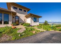 Inviting front entrance with well-maintained landscaping and contemporary architectural features at 8611 Coachlight Way, Littleton, CO 80125