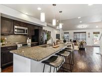 Modern kitchen features a large island with bar seating, dark cabinets, and stainless steel appliances at 409 Terry St # D, Longmont, CO 80501