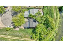 Aerial view of a property with mature trees, a well-maintained lawn and a nearby walking trail at 8032 Lee Ct, Arvada, CO 80005