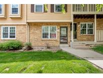Inviting brick townhome with manicured lawn and charming architectural details at 338 Pheasant Run, Louisville, CO 80027