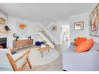 Bright living room boasts a fireplace, modern decor, and open staircase, creating an inviting and stylish space at 9658 W Chatfield Ave # D, Littleton, CO 80128