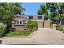 Charming two-story home with a well-manicured lawn, mature trees, and a two-car garage at 9025 Jellison Ct, Broomfield, CO 80021