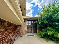 Inviting front door with stone accents and lush greenery, creating a warm and welcoming entrance to the home at 7245 S Dexter St, Centennial, CO 80122
