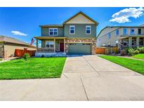 Charming two-story home with a covered porch, stone accents, and well-maintained landscaping at 7888 E 139Th Pl, Brighton, CO 80602