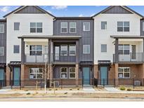 Attractive townhomes with modern design elements and inviting blue doors at 6804 Merseyside Ln, Castle Pines, CO 80108