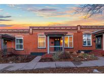 Charming brick home with a cozy front porch and inviting curb appeal at sunset at 1235 31St St, Denver, CO 80205