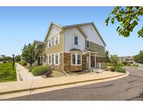 Two-story home boasts a mix of stone and siding, with a manicured lawn and bright, sunny skies at 12704 Jasmine St # E, Thornton, CO 80602