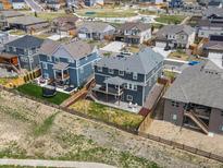 An aerial view of a two story homes with fenced yard and an outdoor patio with green space nearby at 8346 E 132Nd Dr, Thornton, CO 80602
