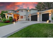 Stunning two-story home featuring a three-car garage and beautifully landscaped front yard at sunset at 7 Sandpiper Cir, Thornton, CO 80241