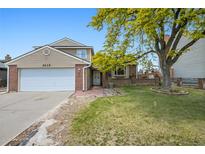 Charming two-story home with brick and siding, complemented by a well-manicured lawn and mature tree at 5419 E 113Th Ave, Thornton, CO 80233