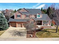 Charming two-story home featuring a three-car garage, brick accents, and covered front porch perfect for relaxing at 580 Crossing Cir, Castle Pines, CO 80108