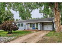 Charming single-story home with a cozy front porch and a well-maintained yard shaded by mature trees at 6055 E Minnesota Dr, Denver, CO 80224