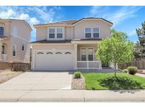 Charming two-story home featuring a spacious front porch and a well-manicured lawn with mature tree at 2354 Cactus Bloom Ct, Castle Rock, CO 80109