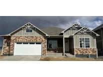 Charming home showcasing a brick and siding exterior, complemented by a pristine white garage door and inviting entryway at 1884 Sawtooth Mountain Dr, Berthoud, CO 80513