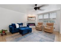 Comfortable living room with a blue velvet couch, modern fireplace, and two leather recliner chairs at 5765 W Atlantic Pl # 104, Lakewood, CO 80227