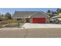 Charming single-Gathering home with brick accents, a red garage door, and a well-maintained front yard at 7814 W Ontario Pl, Littleton, CO 80128