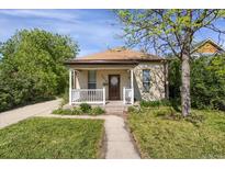 Charming single-story home featuring a cozy front porch, a well-maintained lawn and traditional architectural details at 2415 Chase St, Edgewater, CO 80214