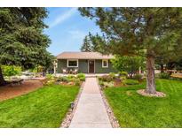 Charming one story home featuring a lush, landscaped front yard, front porch, and walkway at 403 Anderson St, Castle Rock, CO 80104