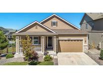 Charming, single-story home with a well-manicured lawn, attached two-car garage, and covered front porch at 22891 E Union Cir, Aurora, CO 80015