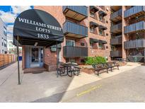 Apartment building featuring a covered entry, red brick facade, and black metal balconies at 1833 N Williams St # 201, Denver, CO 80218