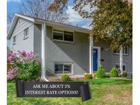 Charming home featuring a manicured front yard with flowering shrubs and a vibrant blue front door at 3841 W Quinn Pl, Denver, CO 80236