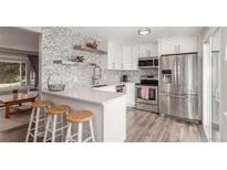 Stylish open kitchen featuring modern stainless steel appliances and white cabinets at 3841 W Quinn Pl, Denver, CO 80236