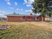 Charming single-Gathering brick home featuring a well-manicured front yard and mature trees at 5479 S Huron Way, Littleton, CO 80120