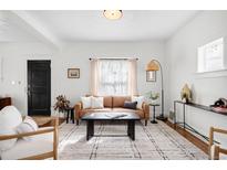 Bright living room features a neutral color palette, light wood floors, and natural light at 5103 Quitman St, Denver, CO 80212