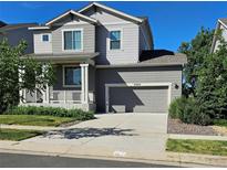 Charming two-story home featuring a covered porch, attached two-car garage, and a well-maintained front yard at 23014 Milford Ln, Parker, CO 80138