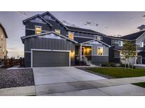 Charming two-story home boasts a gray exterior, two-car garage, and well-manicured lawn at 38 Morgan Cir, Erie, CO 80516