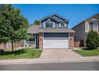 Charming two-story home with blue siding, brick accents, a well-maintained lawn, and a two-car garage at 9640 Moss Rose Cir, Highlands Ranch, CO 80129