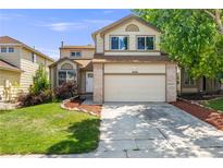 Charming two-story home with a two-car garage and well-maintained landscaping on a sunny day at 12678 W Dorado Pl, Littleton, CO 80127